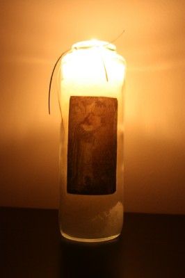 tall candle in glass with Jesus on the front.